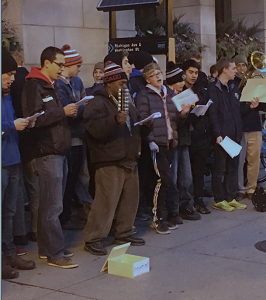 Young men are Christmas caroling with the homeless. 